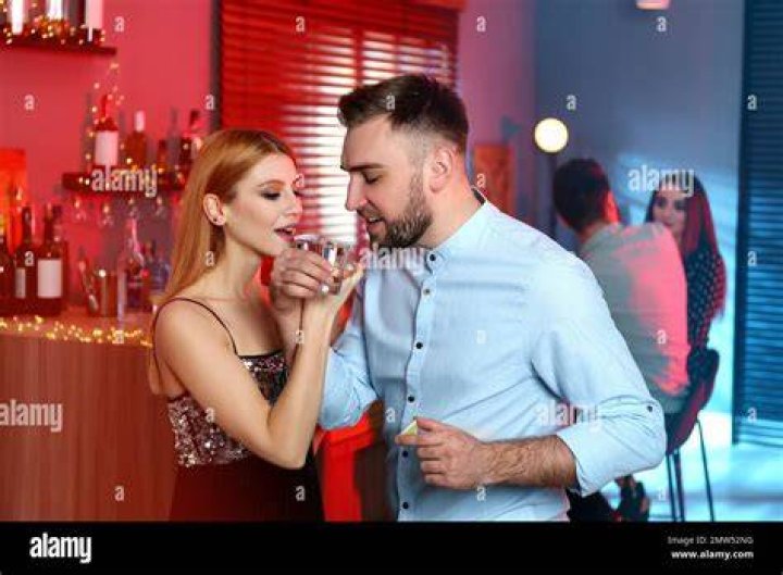 A young couple having tequila shots.