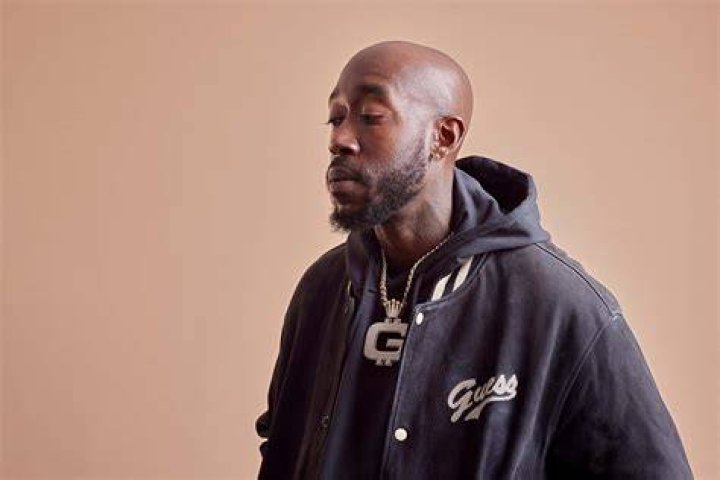 Freddie Gibbs in a black jacket and red hoodie in 2017
