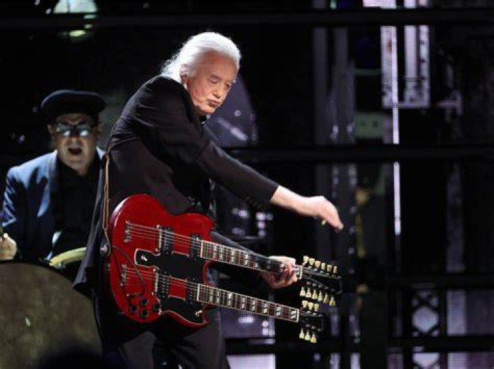 Jimmy Page playing guitar in concert