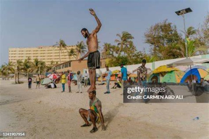 Malick, a 30-year-old acrobat from Guinea, trains on a Dakar beach